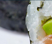 Zoomed In A rolled up piece of food with fish and vegetables in it and the outside is blackSushi 
