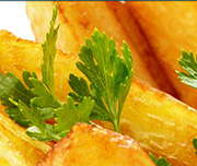 Zoomed In Godl crispy food with a green garnish on it Fries 