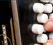 Zoomed In A balck instrument with white buttons and a hand on it Accordion 