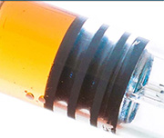 Zoomed In An object with a yellow substance on the side, a black middle and a clear side on the right Syringe 